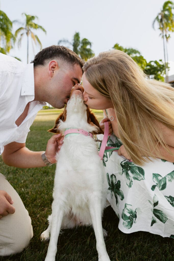 Engaged couple kissing their dog during a dog-friendly engagement photoshoot in Newstead, Brisbane, captured by a Brisbane wedding photographer.