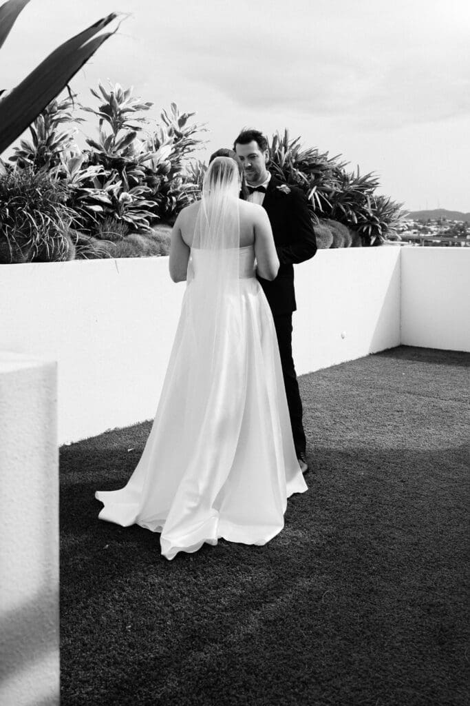 Bride and groom sharing vows during a minimalist outdoor wedding ceremony, photographed from candid overhead and side angles.